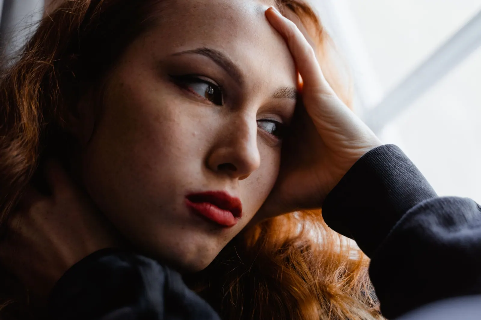 A woman resting her head in her hand, deep in thought